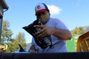 AmeriCorps volunteer Aidan Chadwick places a three-day supply of emergency rations into a container on Sept. 11, 2020. The work was part of United Way of Southeast Alaska AmeriCorps programs day of service in recogntion of 9/11. The supplies packed by volunteers will be shipped by Central Council of Tlingit and Haida Indian Tribes of Alaska to Southeast communities. (Ben Hohenstatt / Juneau Empire File)