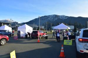 Health workers and volunteers guide hundreds of cars through drive-thru flu shot clinics at Thunder Mountain High School on Saturday, Oct. 24, 2020. A collaboration between state and local authorities, health officials set up the clinic to mass vaccinate Juneauites as an additional deterrent against the spread of the coronavirus. (Peter Segall / Juneau Empire)