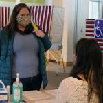Voter Holly Gundelfinger talks to an election official in the Mendenhall Valley Public Library on Nov. 3, 2020. (Ben Hohenstatt / Juneau Empire)