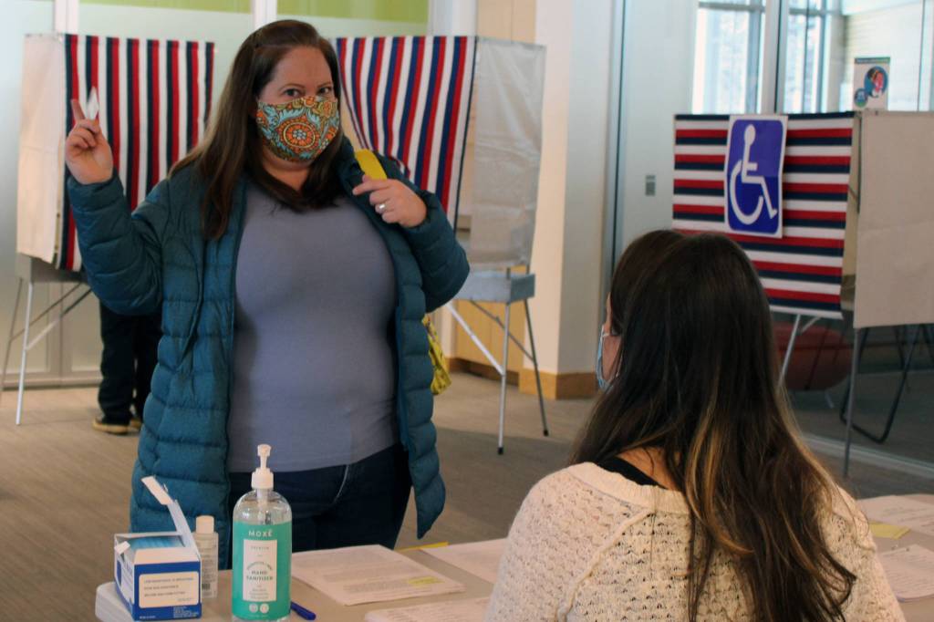 Voter Holly Gundelfinger talks to an election official in the Mendenhall Valley Public Library on Nov. 3, 2020. (Ben Hohenstatt / Juneau Empire)