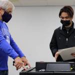 Election official Steve Lewis directs voter Patrick Endozo, who attempts to feed his completed ballot into a scanning machine at a polling place inside Nugget Mall on Election Day. Election officials said shortly before 5 p.m. that about 150 more people had voted at the polling place than voted there in the state's August primary. (Ben Hohenstatt / Juneau Empire)