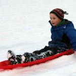 Alex Weiss, 9, sleds down a hill at Twin Lakes Friday, Nov. 20. (Ben Hohenstatt / Juneau Empire)