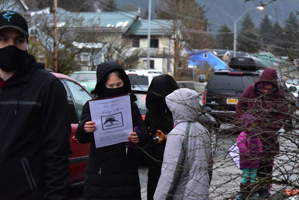 Julia Barrientes and her daughters, Anhkaawoo and Romona, examine the menu for a fundraiser photoshoot with a live turkey for Juneau-Douglas High School: Yadaa.at Kalés vocational programs on Wednesday, Nov. 25, 2020. (Peter Segall / Juneau Empire)