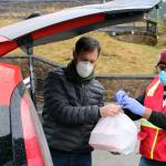 Volunteer Linnell Bush helps Jeremy Schlosser load up the trunk of a vehicle with meals in downtown Juneau on Thursday, Nov. 26. Schlosser then distributed those meals to Fireweed Place, the St. Vincent de Paul Society shelter and Trillium Landing. (Ben Hohenstatt / Juneau Empire)