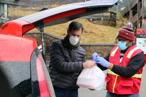 Volunteer Linnell Bush helps Jeremy Schlosser load up the trunk of a vehicle with meals in downtown Juneau on Thursday, Nov. 26. Schlosser then distributed those meals to Fireweed Place, the St. Vincent de Paul Society shelter and Trillium Landing. (Ben Hohenstatt / Juneau Empire)