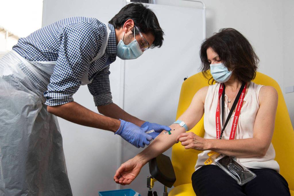 In this undated photo issued by the University of Oxford, a volunteer is administered the coronavirus vaccine developed by AstraZeneca and Oxford University, in Oxford, England. Pharmaceutical company AstraZeneca said Monday Nov. 23, 2020, that late-stage trials showed its coronavirus vaccine was up to 90% effective, giving public health officials hope they may soon have access to a vaccine that is cheaper and easier to distribute than some of its rivals. (University of Oxford/John Cairns via AP)