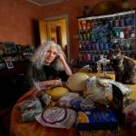 Phyllis Marder poses with her cat, Nellie, with food she recently obtained from a local food bank in the dining room of her home in Evanston, Ill., on Thursday, Nov. 5, 2020. At first, Marder, 66, didnt tell anyone about going to food pantries. Then she had a change of heart. Keeping a secret makes things get worse, she says … and makes me feel worse about myself, and so I decided that it was more important to talk about it. (AP Photo/Charles Rex Arbogast)