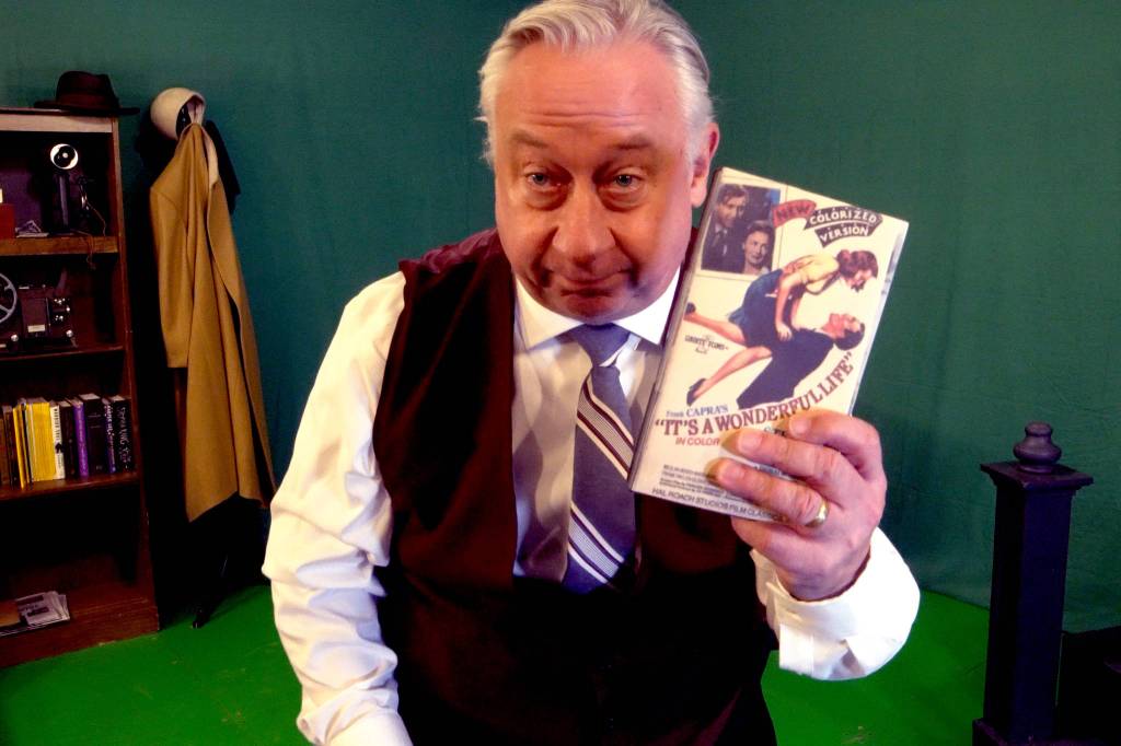 Courtesy Photo / Perseverance Theatre
Wes Mann, who will embody multiple characters in Perseverance Theatres upcoming This Wonderful Life, holds up a copy of the classic film that was adapted into a one-actor stage show while standing in front of a green screen that will be transformed via digital effects. This Wonderful Life will be available on demand beginning the evening of Dec. 19.