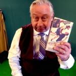 Wes Mann, who will embody multiple characters in Perseverance Theatres upcoming This Wonderful Life, holds up a copy of Its A Wonderful Life, which was adapted into a one-actor stage show, while standing in front of a green screen that will be transformed via digital effects. This Wonderful Life will be available on demand beginning the evening of Dec. 19. (Courtesy Photo / Perseverance Theatre)