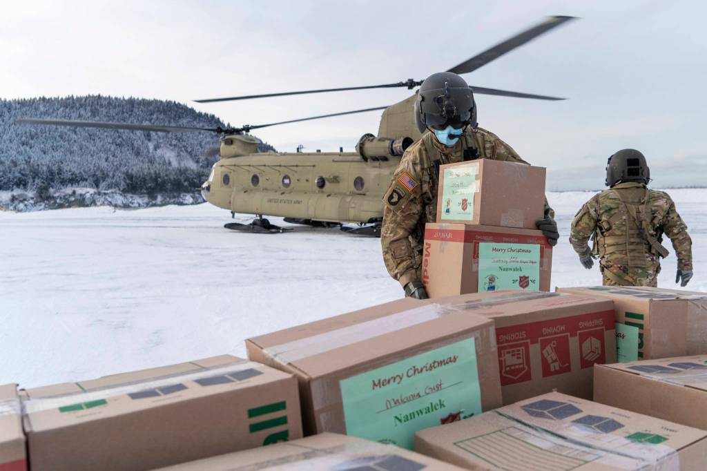 In this photo provided by the Alaska National Guard, soldiers from 1st Battalion, 207th Aviation Regiment, unload gifts from a CH-47 Chinook helicopter in Nanwalek, Alaska, during Operation Santa Claus, on Dec. 11, 2020. Operation Santa Claus is an Alaska National Guard annual community outreach program that provides Christmas gifts, books, school supplies and stocking stuffers to children in rural Alaskan communities. The Alaska National Guard and the Salvation Army were able to provide and deliver gifts for the programs 65th year, but had to scale back distribution parties that are normally held in the villages because of COVID-19. (Edward Eagerton / U.S. Army National Guard)