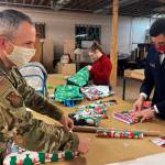 Chief Master Sgt. Winfield Hinkley Jr., Command Senior Enlisted Leader of the Alaska National Guard, left, Makayla Hikley, middle, and Maj. John Brackenbury, divisional commander with the Salvation Army, Alaska Division, wrap gifts in Anchorage, Alaska, that will be sent to children in three rural Alaska villages, on Nov. 17, 2020. The Alaska National Guard and the Salvation Army were able to provide and deliver gifts for the programs 65th year, but had to scale back distribution parties that are normally held in the villages because of COVID-19. (AP Photo / Mark Thiessen)