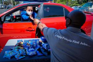 Brandon Earl, right, helps David Lenus, a job seeker, fill out an application at a drive up job fair for Allied Universal during the coronavirus pandemic, in Gardena, Calif. Coronavirus restrictions in California have put millions of people out of work, increasing the states unemployment rate earlier this year to levels not seen since the Great Depression. (AP Photo / Chris Carlson)