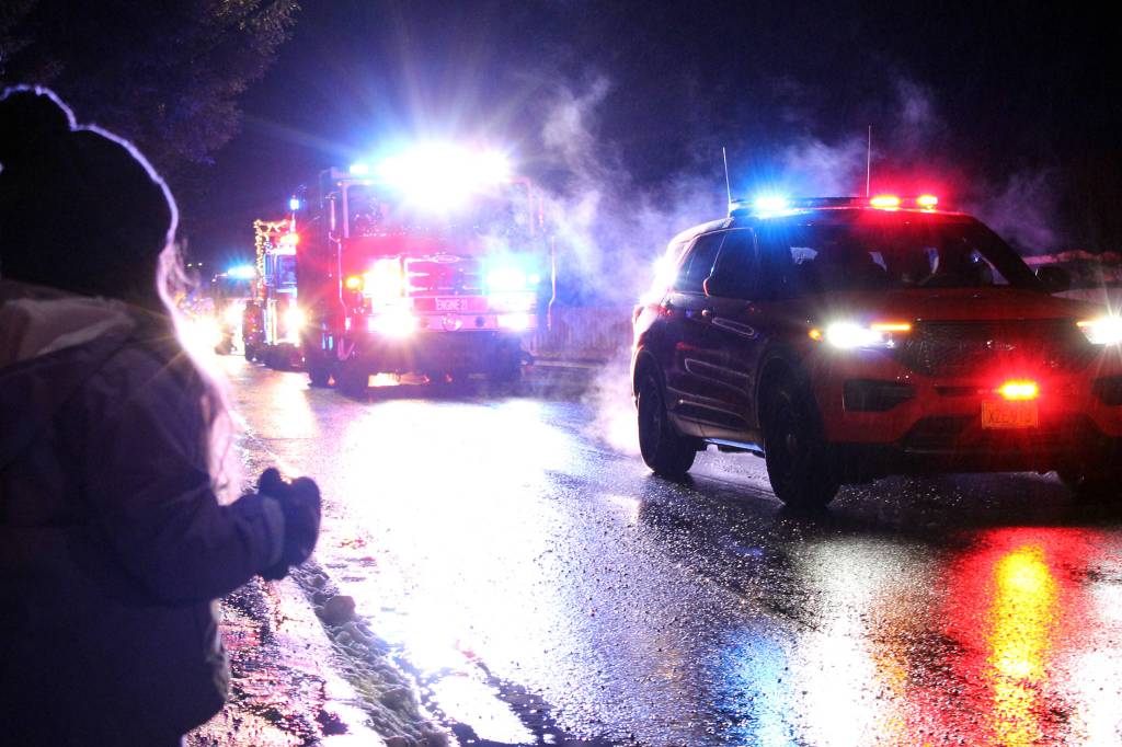 Ben Hohenstatt / Juneau Empire
Amaya Suckow,6, watches a police car and fire truck drive by during a holiday parade on Dec. 18.