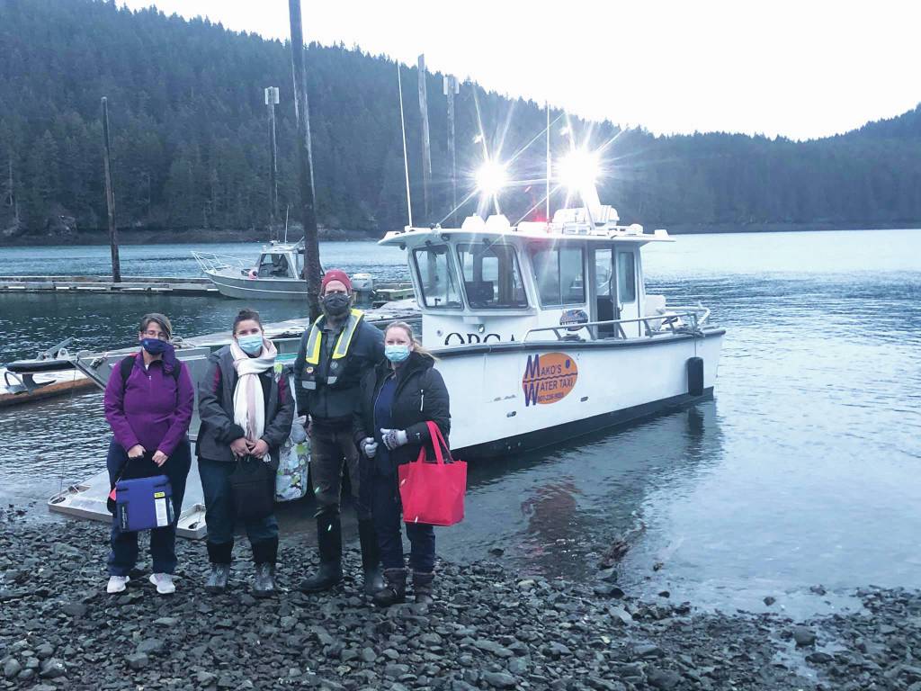 Curtis Jackson, second from right, poses on Thursday, Dec. 17, 2020, with SVT Heath & Wellness Center health care workers in Jakolof Bay, Alaska, after making a trip across Kachemak Bay from Homer to deliver the medical team and Pfizer COVID-19 vaccine. From left to right are nurse Candice Kreger, family nurse practitioner Kourtney Holder, Jackson, and family nurse practitioner Julie Drude. The health care workers then went by road to Seldovia. (Photo by Janel Harris courtesy of Mako's Water Taxi)