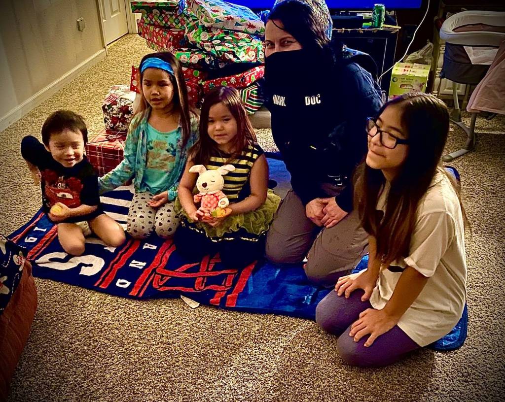 Courtesy photo / APOA
Pretrial Enforcement Officer Linda Wahl delivers presents to and Donald, Sandra, Alice, and Kaylanna as part of the Alaska Police Officers Association annual Shop with a Cop event.