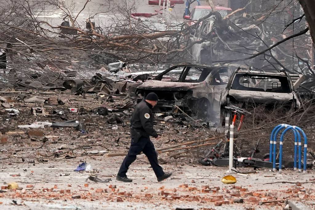 A law enforcement member walks past damage from an explosion in downtown Nashville, Tenn., Friday, Dec. 25, 2020. Buildings shook in the immediate area and beyond after a loud boom was heard early Christmas morning. (AP Photo / Mark Humphrey)