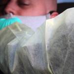 Michael S. Lockett has his nose swabbed by Sarah Palmer during a drive-thru COVID-19 test on Dec. 31. City and Borough of Juneau is offering free, asymptomatic testing by appointment. (Ben Hohenstatt / Juneau Empire)