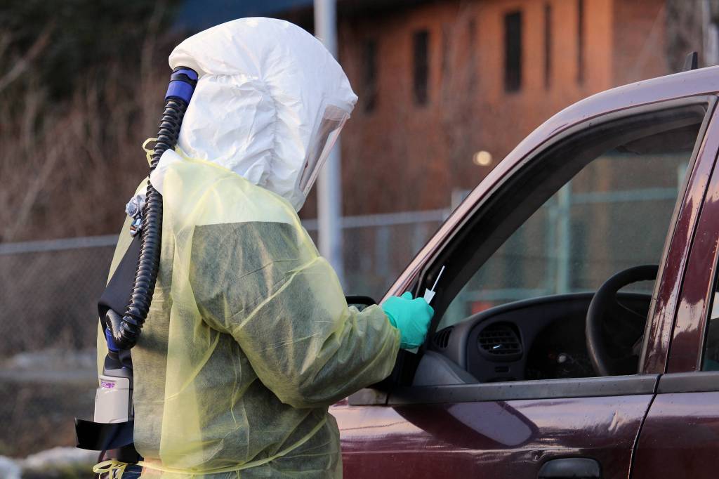 Sarah Palmer talks to a driver before administering a COVID-19 test. The City and Borough of Juneau is offering free, asymptomatic testing. The drive-thru testing is available daily through Jan. 10 with the exception of New Years Day. (Ben Hohenstatt / Juneau Empire)