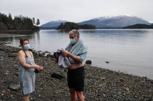 Sherri McDonald and Reid Tippets dry off after their annual dip in the water at Auke Recreation Picnic Area on New Years Day, Jan. 1, 2021. Tippets said hed done the dip for 11 years in a row. The Polar Bear Dip, held for 30 years at Auke Rec, was canceled this year over pandemic concerns, but some individual households opted to make the dip with their families, with masks, distancing, and care very much in evidence, while other pods had fires or walked dogs next to the cold ocean. (Michael S. Lockett / Juneau Empire)