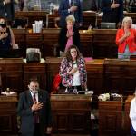 State Representatives stand at their desks during the Pledge of Allegiance in the Iowa House chambers, at the Statehouse in Des Moines, Iowa, in June 2020. As states brace for a coronavirus surge following holiday gatherings, one place stands out as a potential super-spreader site, the statehouses where lawmakers will help shape the response to the pandemic. (AP Photo / Charlie Neibergall)