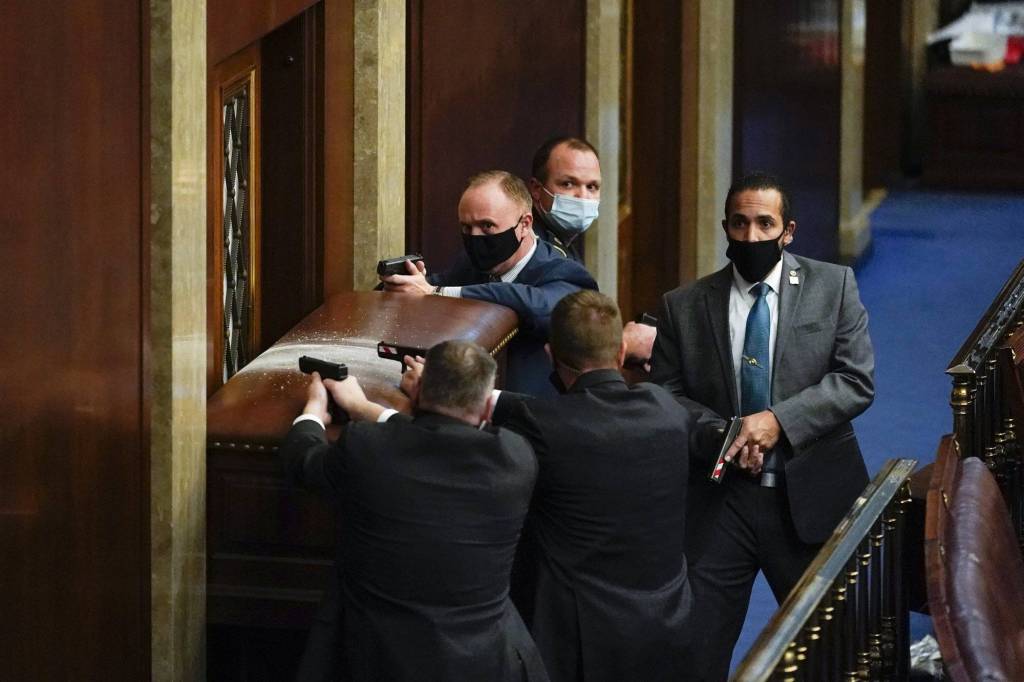 U.S. Capitol Police with guns drawn stand near a barricaded door as protesters try to break into the House Chamber at the U.S. Capitol on Wednesday, Jan. 6, 2021, in Washington. (AP Photo/Andrew Harnik)