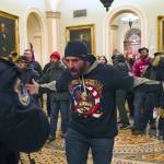 Trump supporters gesture to U.S. Capitol Police in the hallway outside of the Senate chamber at the Capitol in Washington, Wednesday, Jan. 6, 2021. (AP Photo/Manuel Balce Ceneta)