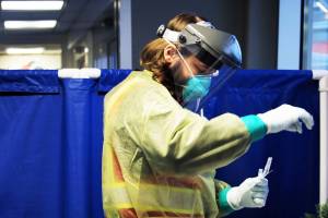 Emergency worker Tyler Morgan prepares to administer a COVID-19 test at Juneau International Airport. (Ben Hohenstatt / Juneau Empire)