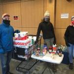 Marc Wheeler, Maddie Kombrink, and Kristi Kraft of Coppa volunteered with the Black Awareness Association of Juneau to help hold a food and childcare needs drive at the Foodland IGA on Dr. Martin Luther King Jr. Day, Jan. 18, 2021. (Michael S. Lockett / Juneau Empire)