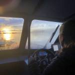 The authors fiancee, Abby, navigates their boat in the fading afternoon light. Shortly after returning to the dock, an otter took up residence aboard. (Jeff Lund / For the Juneau Empire)
