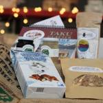 A collection of items that can be included inside a Taste Alaska! box sit on top of a table inside Juneau Food Tours on Saturday, Jan. 23. (Ben Hohenstatt / Juneau Empire)