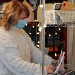 Midgi Moore, CEO of Juneau Food Tours, stocks a shelf inside the businesss new downtown location on Shattuck Way. The new space allows Juneau Food Tours to have an easily accessible storefront and more easily prepare Taste Alaska! boxes. (Ben Hohenstatt / Juneau Empire)