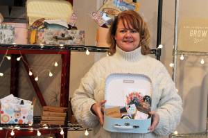 Midgi Moore, CEO of Juneau Food Tours, holds up a Taste Alaska! Alaska Sweetheart Box inside Juneau Food Tours' new location on Shattuck Way. The boxes, which were launched in June, are a way for Juneau Food Tours to give people a taste of the capital city amid the pandemic. (Ben Hohenstatt / Juneau Empire)