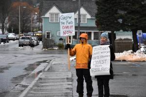 Dick Farnell, right, and Suzanne Cohen of environmental group 350Juneau hold signs outside the Alaska Permanent Fund Corporation building during APFCs Board of Directors quarterly meeting on Wednesday, Feb. 19, 2020. (Peter Segall / Juneau Empire File)
