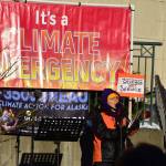 Juneau poet Lin Davis reads a poem at a demonstration in Dimond Court Plaza across from the Alaska State Capitol on Tuesday, Jan. 26, 2021. Dozens of protestors gathered to support strong actions by the state to combat climate change. (Peter Segall / Juneau Empire)