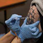 Lydia Steele administers the coronavirus vaccine to T.J. Cramer during a clinic at Centennial Hall on Feb. 11, 2021. (Michael S. Lockett / Juneau Empire)
