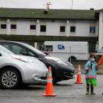 Nathea Burnet holds both a plastic ax and her grandmother, Patricia Forrest's, hand while looking at electric vehicles during Juneau Electric Vehicle Association's road rally Saturday, Sept. 26, 2020. On a per capita basis, there is one electric vehicle per 76 residents in Juneau. There were 418 EVs registered in Juneau as of November 2020. (Ben Hohenstatt / Juneau Empire File)