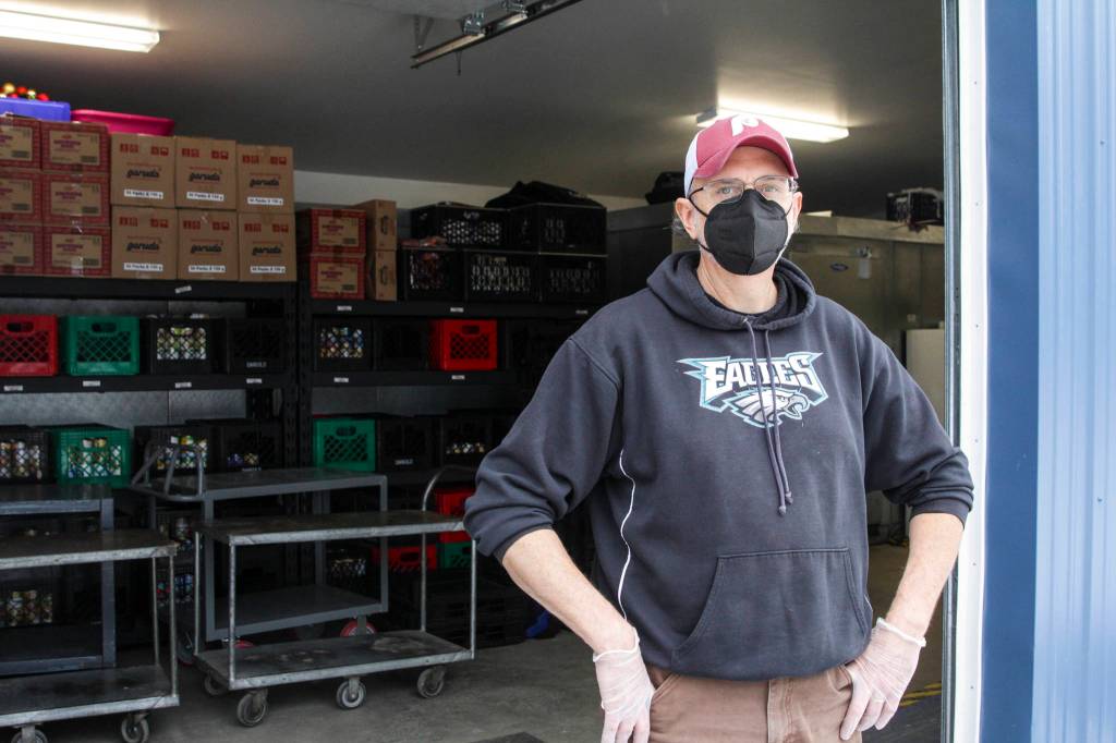 Chris Shapp, manager of the Southeast Alaska Food Bank, stands outside the food bank on Feb. 18, 2021 as a van full of food donations arrives. (Michael S. Lockett / Juneau Empire)