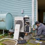 Michael Penn / Juneau Empire file
Air-source heat pumps, like the one in this 2015 photo of Jake Eames, right, and David Nash installing a pump, are an example of a load-side technology that can increase energy efficiency. Load-side technologies are absolutely key to our ability to reduce greenhouse emissions in the energy sector, said director of energy services at Alaska Electric Light and Power Alec Mesdag.