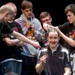 Juneau-Douglas High School head basketball coach Robert Casperson gets his hair cut on stage by senior Treyson Ramos during a school assembly Wednesday, holding up his end of the bargain that he would shave his head if his team won the state championship title. Casperson said he trusted the 2016 team's senior class a lot.