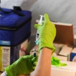 A health worker prepares a dosage of COVID-19 vaccine at a clinic at Centennial Hall on Feb. 11. A surge in vaccine availability means more people can get the vaccine, but so far few people are being required to get it. (Michael Lockett / Juneau Empire file)