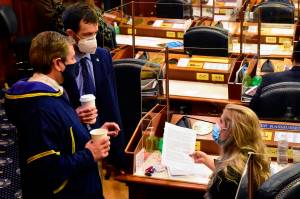 From left to right: Alaska state Reps. Chris Tuck, D-Anchorage, Zack Fields, D-Anchorage, and Sara Rasmussen, R-Anchorage, speak on the Alaska House floor on Friday, March 5, 2021. The House passed a Sense of the House on Friday, condemning as inappropriate and objectifying comments Fields had made toward Rasmussen last month. (Peter Segall / Juneau Empire)
