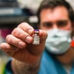 Bartlett Regional Hospital pharmacist Chris Sperry holds a vial of COVID-19 vaccine on Dec. 15, 2020. (Michael S. Lockett / Juneau Empire File)