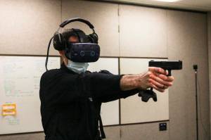 Michael S. Lockett / Juneau Empire
Detective Patrick Taylor draws a sidearm-controller Wednesday during a VR training simulation as Sgt. Sterling Salisbury controls the scenario from a computer elsewhere.