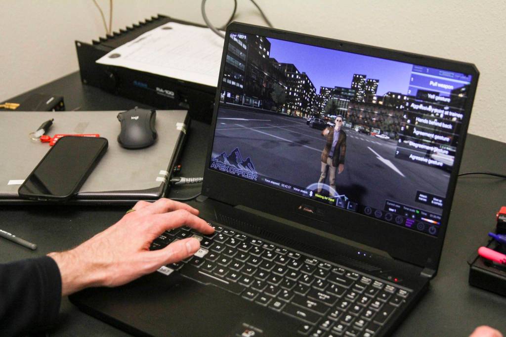 Detective Patrick Taylor controls a virtual scenario involving an agitated subject with a knife in VR as Sgt. Sterling Salisbury practices de-escalation techniques on March 17, 2021. (Michael S. Lockett / Juneau Empire)