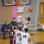 Juneau-Douglas High School Yadaa.at Kalé senior Garrett Bryant shoots from under the basket against Ketchikan High School senior Joshua Gentry (13) during the second half in the boys varsity Region V basketball championship at Clarke Cochrane Gymnasium on Saturday, March 20, 2021. JDHS won 87-68. (Dustin Safranek / Ketchikan Daily News)
