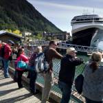 Tourists view Juneaus downtown harbor in August 2015. (Michael Penn / Juneau Empire File)