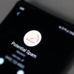 A phone screen displays a message warning of a potential spam call. Juneau Police Department warns residents to be aware of a scam involving someone claiming to be with Social Security Administration. (Ben Hohenstatt / Juneau Empire)