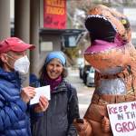 Peter Segall / Juneau Empire 
Doug Woodby, co-chair of environmental group 350Juneau, holds up a letter addressed to the CEO of Wells Fargo alongside Irene Alexakos and Dick Farnell, wearing the costume. The group delivered the letter urging divestment from the fossil fuel industry to the banks branch in downtown Juneau on Friday, April 2, 2021.