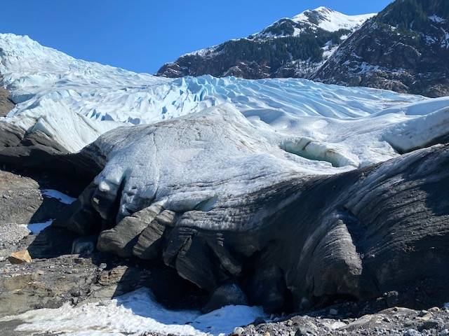 The edge of the Mendenhall Glacier, as seen on April 21, is black from scouring the side of the ridge as it moves down the valley. Courtesy Photo / Denise Carroll)