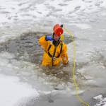 Capt. Jayme Johns, head of the Capital City Fire/Rescues water rescue team, chucks a rope bag back to shore during CCFRs annual ice rescue training at Twin Lakes on April 7, 2021. (Michael S. Lockett / Juneau Empire)
